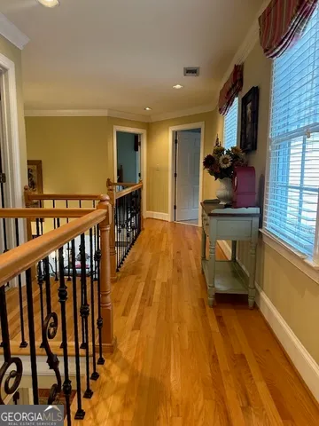 a view of hallway with wooden floor and furniture