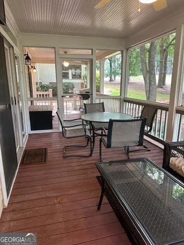 a living room with furniture a large window and wooden floor