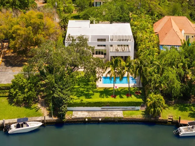 an aerial view of a house with a garden and lake view