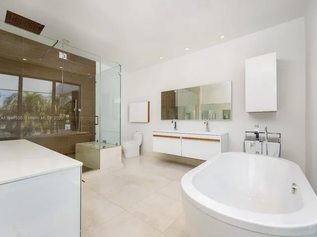 a bathroom with a double vanity sink a mirror and bathtub