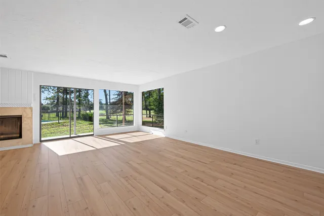 a view of room with wooden floor and fireplace