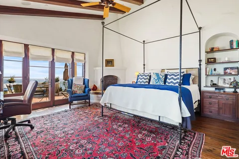 a spacious bedroom with a bed a couch and wooden floor
