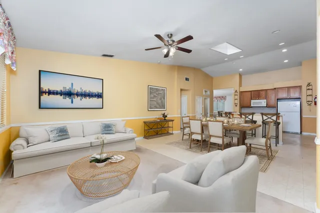 a living room with furniture kitchen view and a chandelier