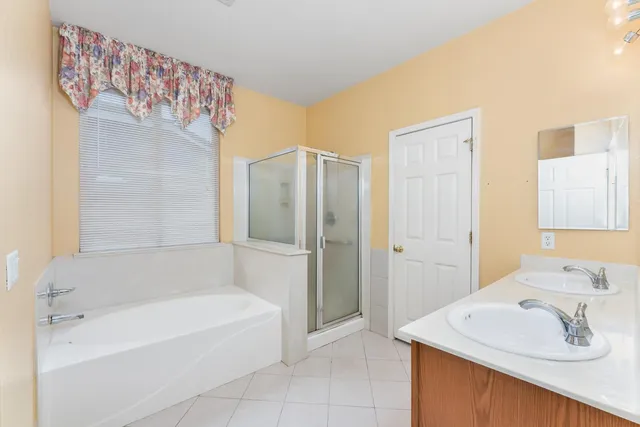 a bathroom with a bathtub a sink and a mirror