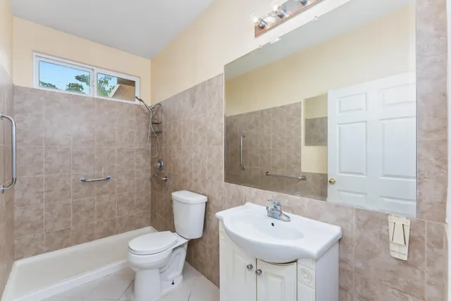 a bathroom with a sink a toilet and shower