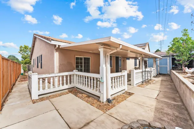 a view of a backyard with a large tree and wooden fence