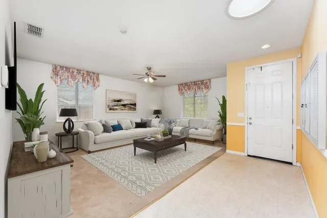 a living room with furniture potted plant and a large mirror