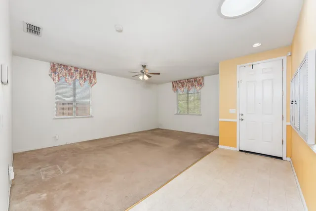 an empty room with windows and cabinet