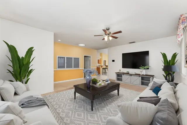 a living room with furniture a flat screen tv and a potted plant
