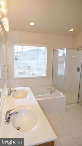 a bathroom with a tub a sink and mirror