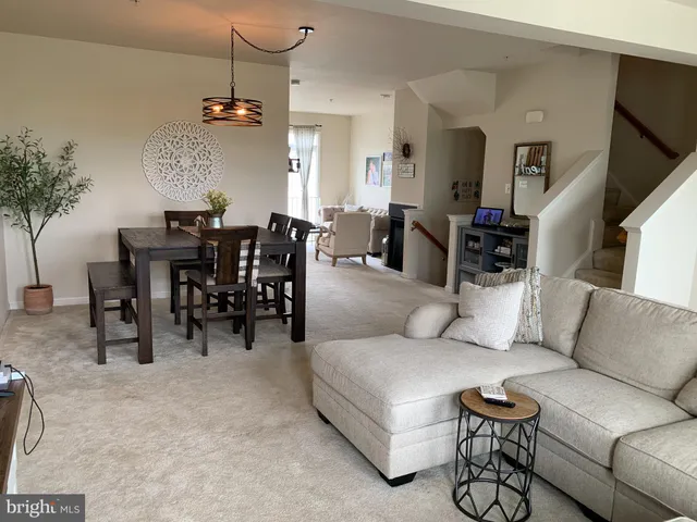 a living room with furniture dining area and a chandelier