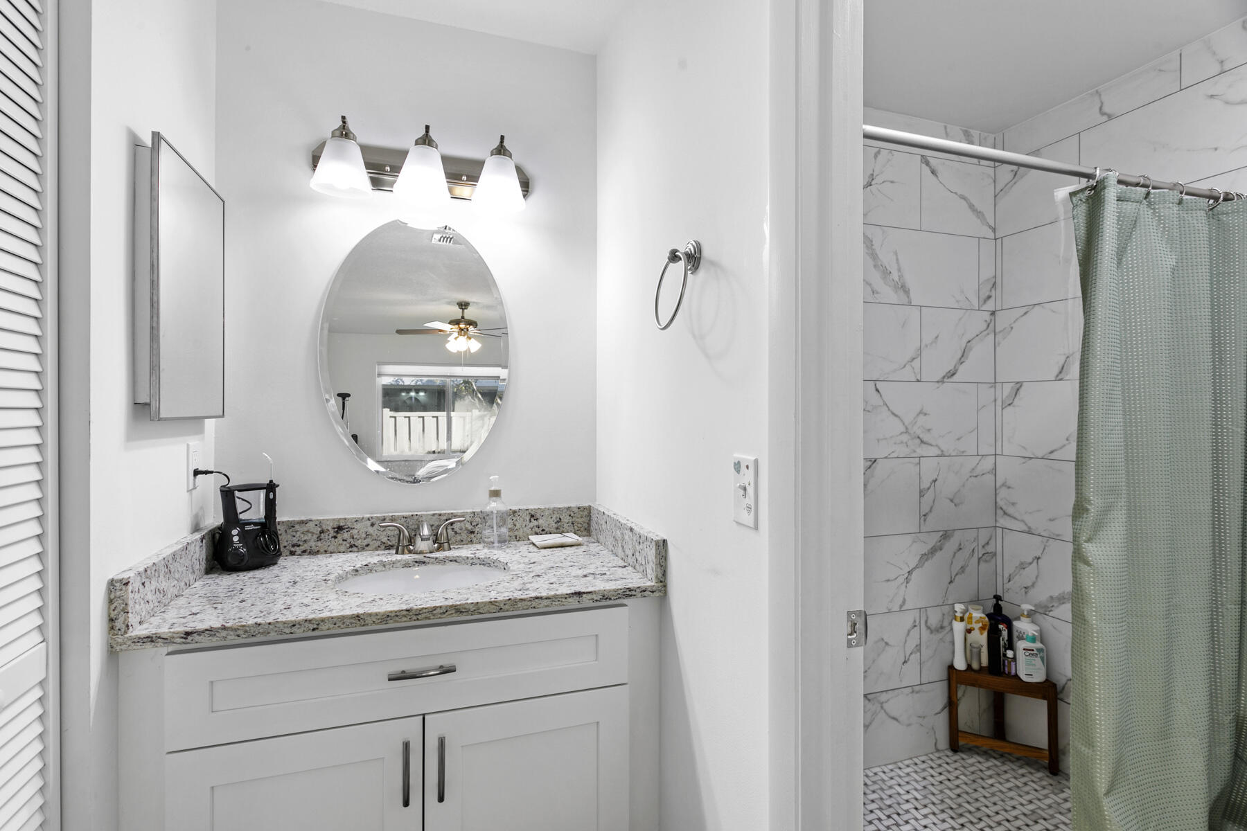 140 Moccasin Trail South Jupiter, FL 33458 - Photo 12 of 18 a bathroom with a granite countertop sink and a mirror