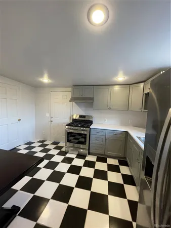 a kitchen with a checkered floor and white cabinets