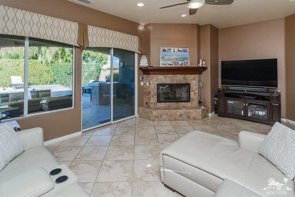 66 Paris Way Rancho Mirage, CA 92270 - Photo 13 of 32 a living room with furniture a flat screen tv and a fireplace