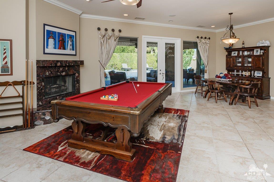 66 Paris Way Rancho Mirage, CA 92270 - Photo 16 of 32 a living room with furniture a pool table and a fireplace