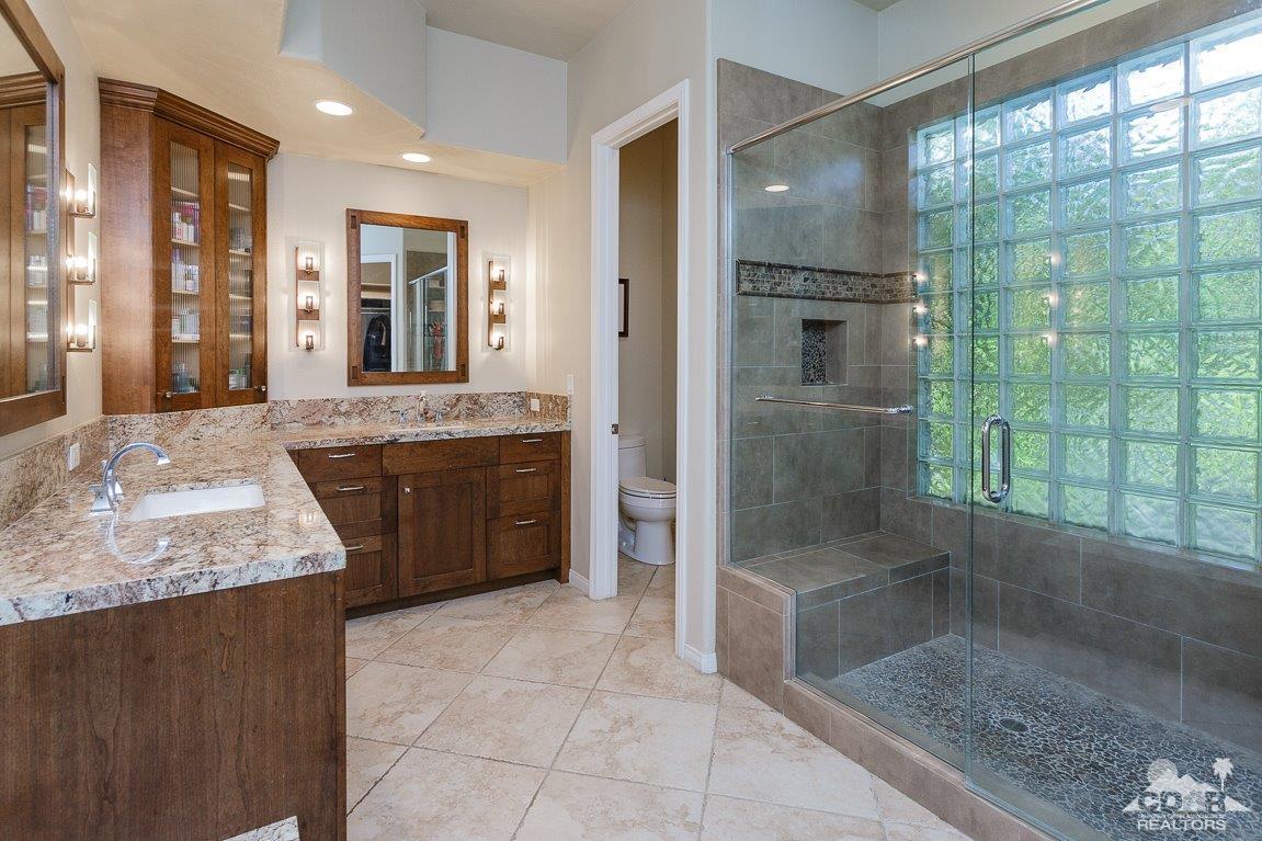 66 Paris Way Rancho Mirage, CA 92270 - Photo 20 of 32 a large bathroom with a granite countertop shower a sink and a mirror
