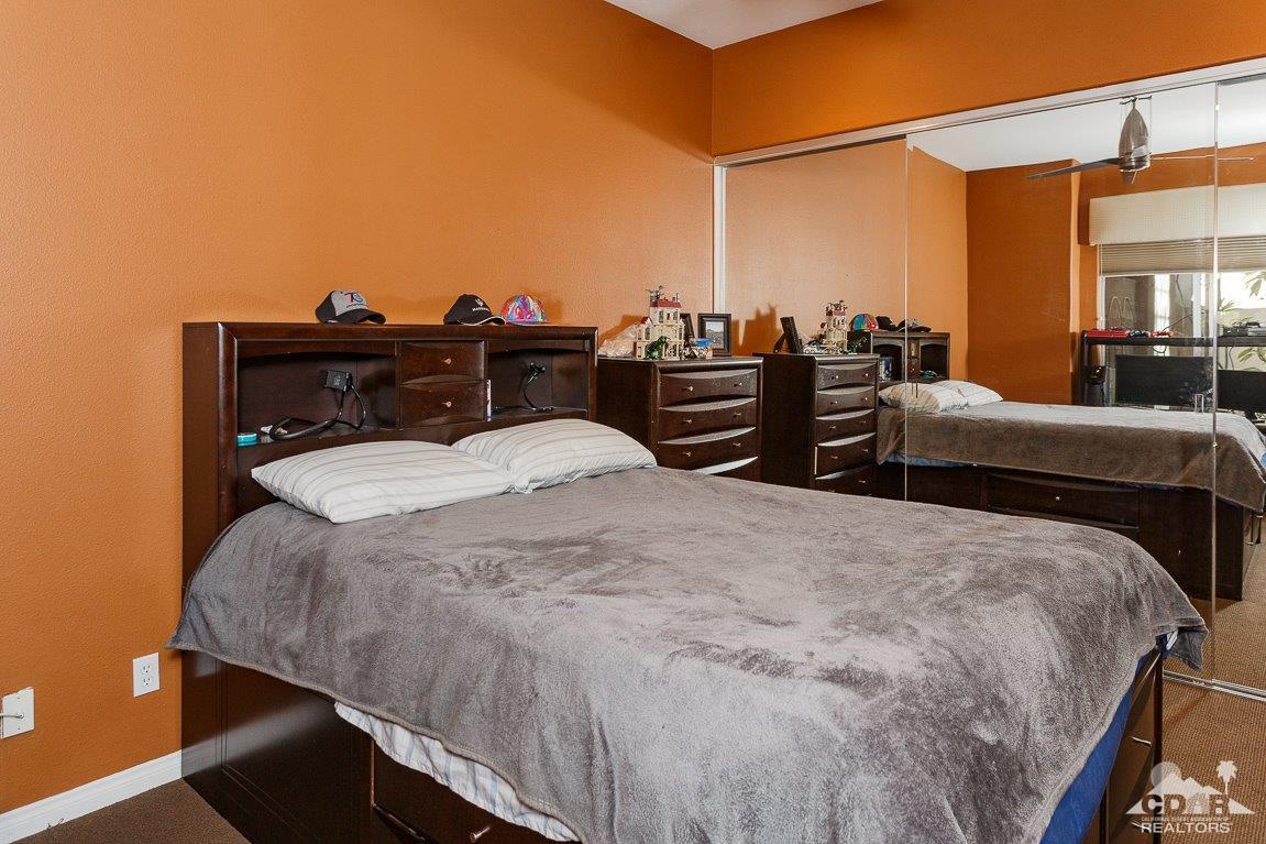 66 Paris Way Rancho Mirage, CA 92270 - Photo 21 of 32 a bedroom with a bed and dresser with wooden floor