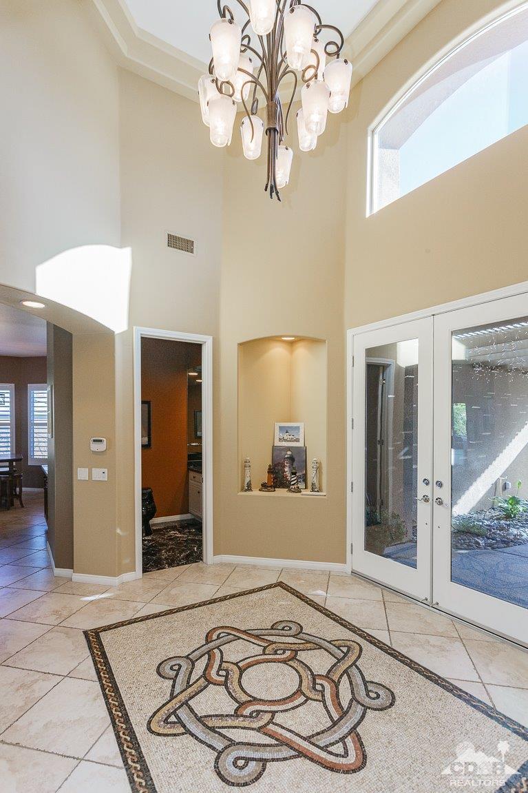 66 Paris Way Rancho Mirage, CA 92270 - Photo 7 of 32 a bedroom with a large bed and a chandelier