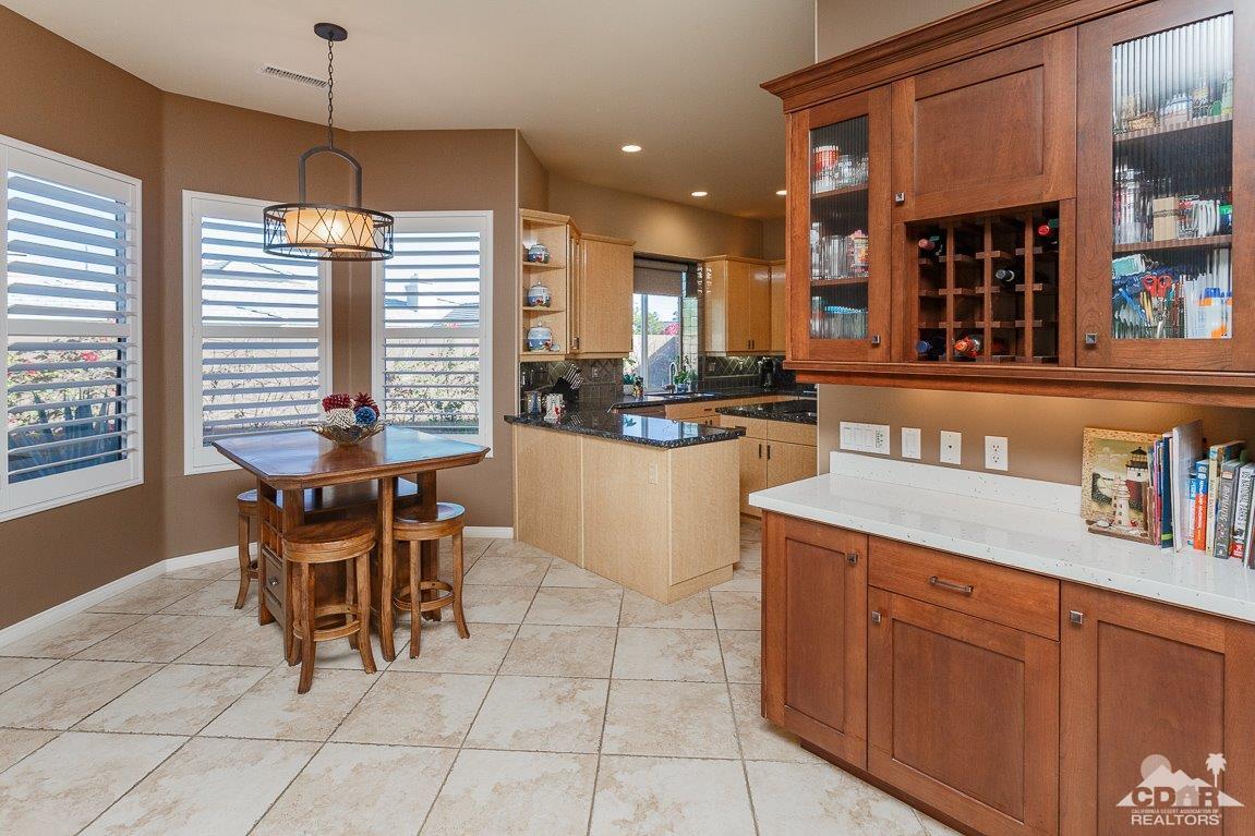 66 Paris Way Rancho Mirage, CA 92270 - Photo 10 of 32 a dining hall with stainless steel appliances kitchen island granite countertop a table and chairs in it