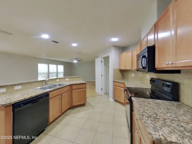 a large kitchen with stainless steel appliances granite countertop a sink stove and granite counter tops