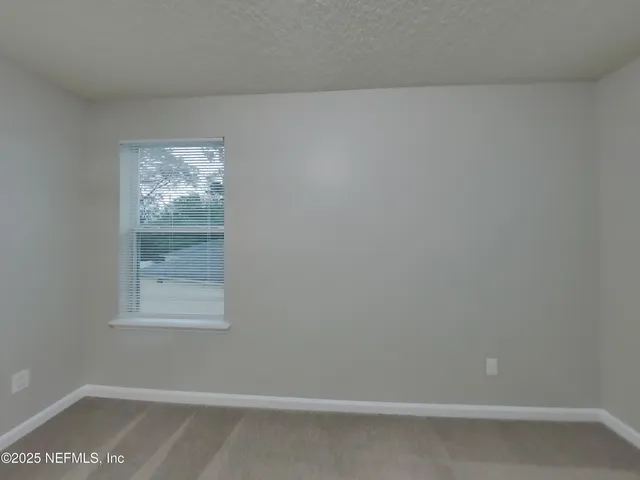 a view of an empty room with closet