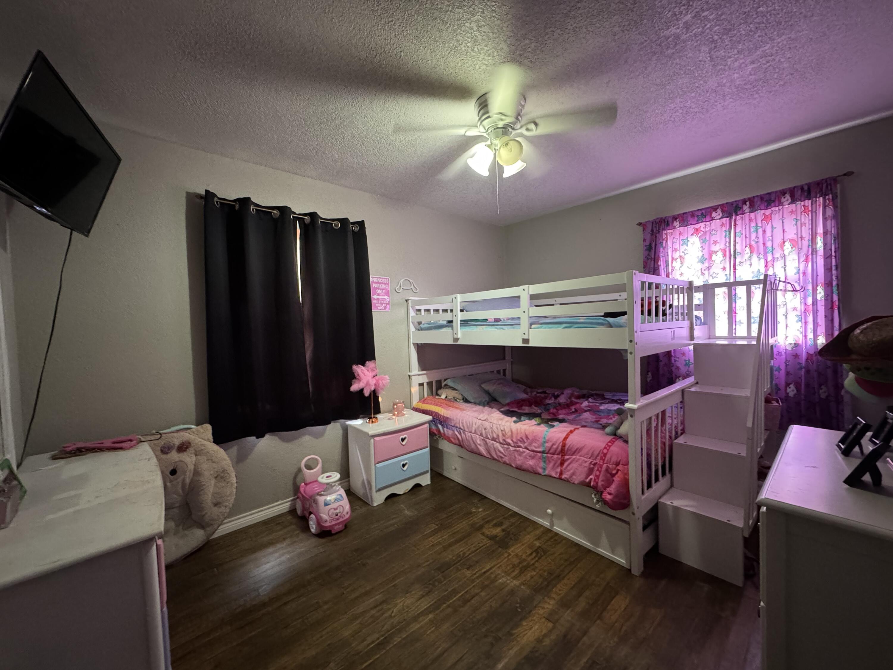 3808 37th Street Lubbock, TX 79413 - Photo 10 of 19 a bedroom with furniture and a flat screen tv