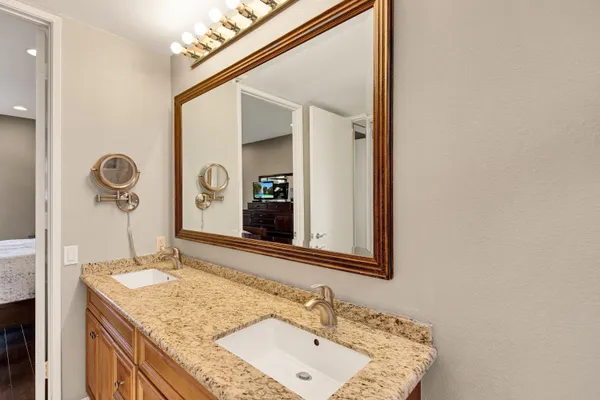 a bathroom with a granite countertop sink and a mirror