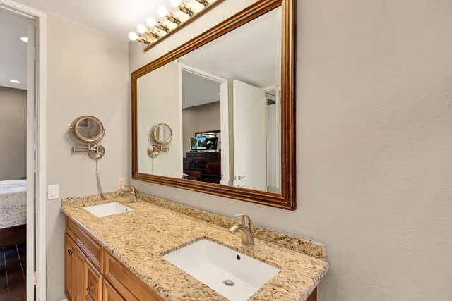 a bathroom with a granite countertop sink and a mirror