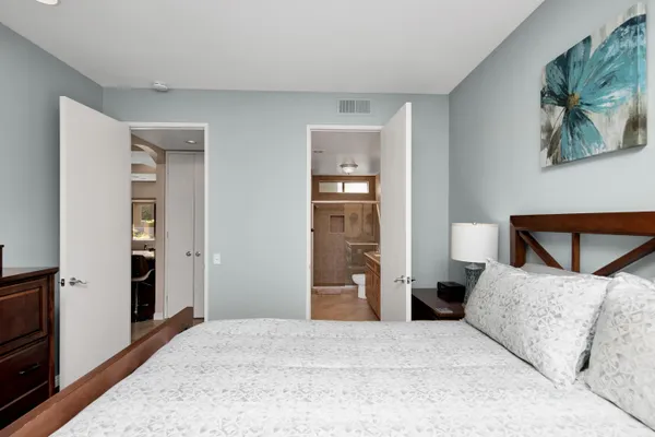 a bedroom with a bed and a painting on the wall