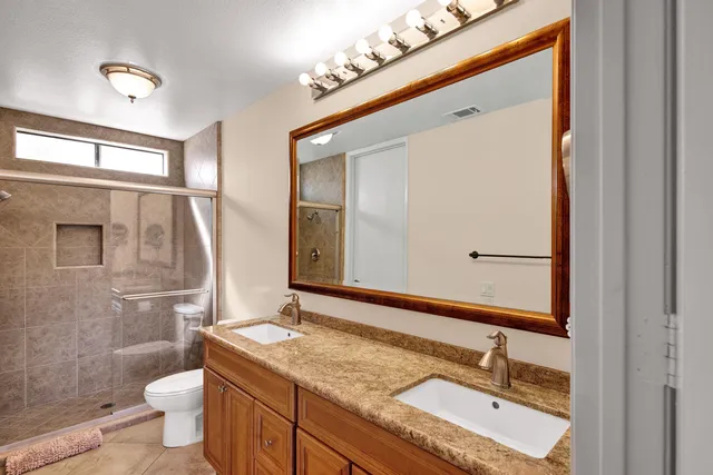 a bathroom with a granite countertop sink toilet and shower
