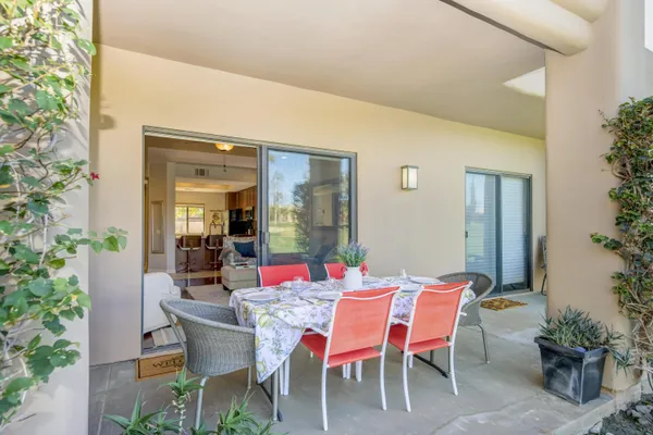 a dining room with furniture and potted plants