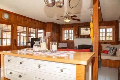 a view of a kitchen with granite countertop a sink a stove and cabinets