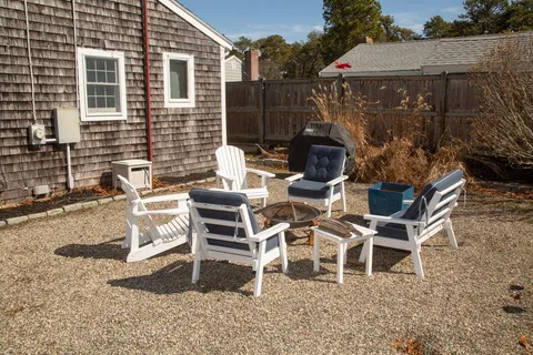 a view of a patio with table and chairs with wooden fence