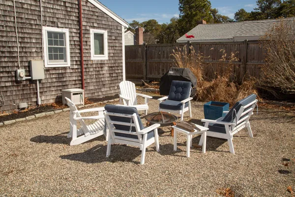 a view of a patio with table and chairs with wooden fence
