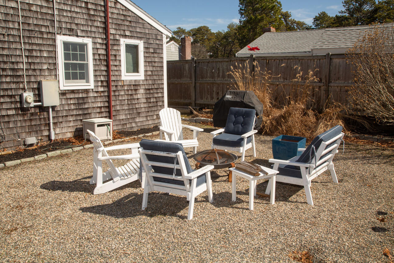 10 Wixon Road Dennis Port, MA 02639 - Photo 3 of 25 a view of a patio with table and chairs with wooden fence