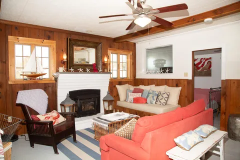 a living room with furniture fireplace and a large window
