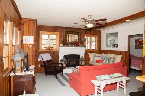 a living room with furniture a fireplace and a large window