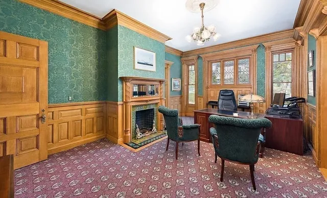 a living room with furniture a fireplace and a chandelier