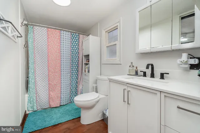 a bathroom with a sink a toilet and shower