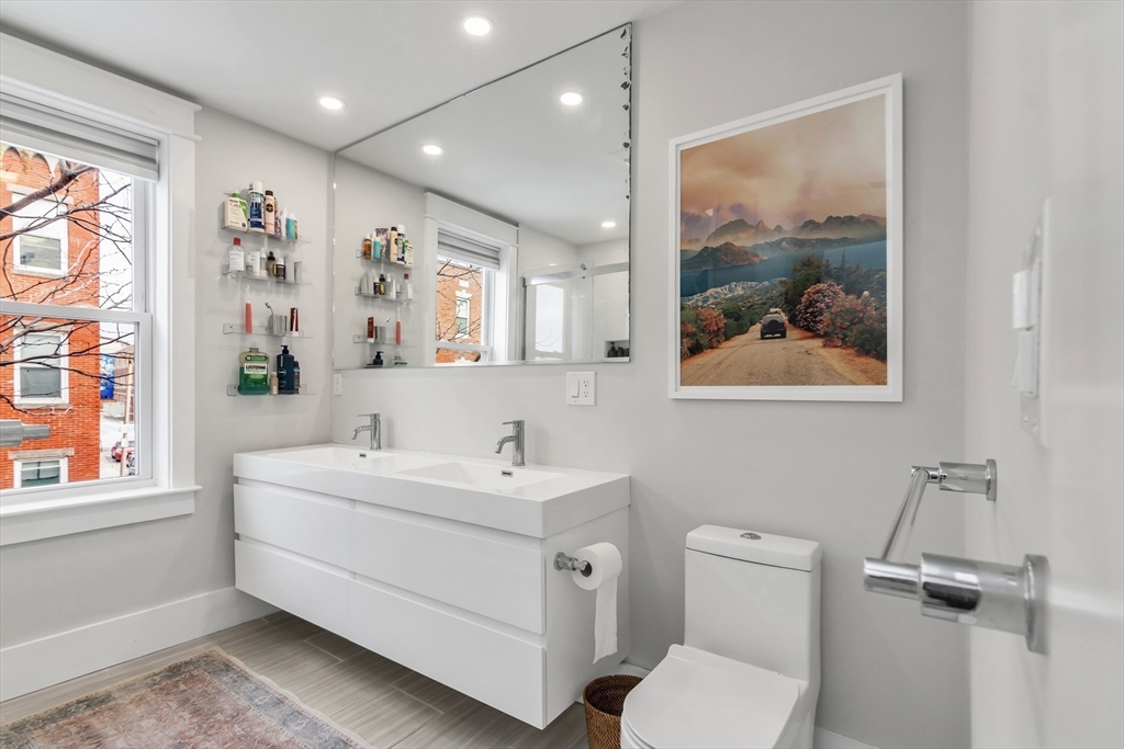 215 Maverick Street, Unit 2 Boston, MA 02128 - Photo 17 of 22 a bathroom with a toilet a sink and mirror