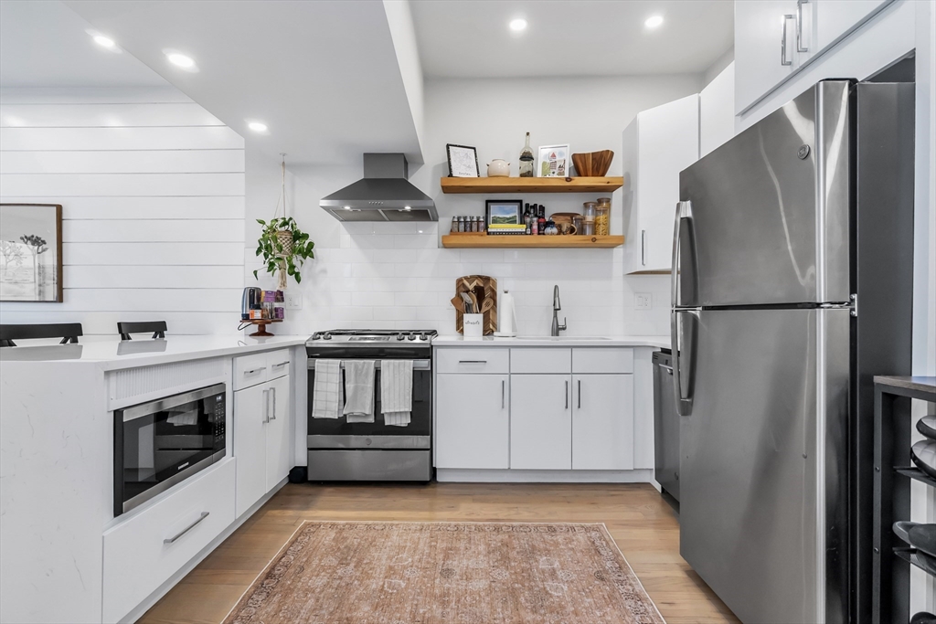 215 Maverick Street, Unit 2 Boston, MA 02128 - Photo 4 of 22 a kitchen with stainless steel appliances a refrigerator sink and stove