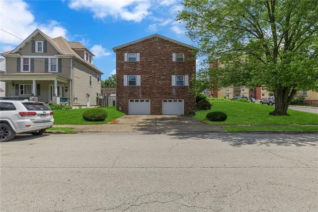 a front view of a house with a yard and garage