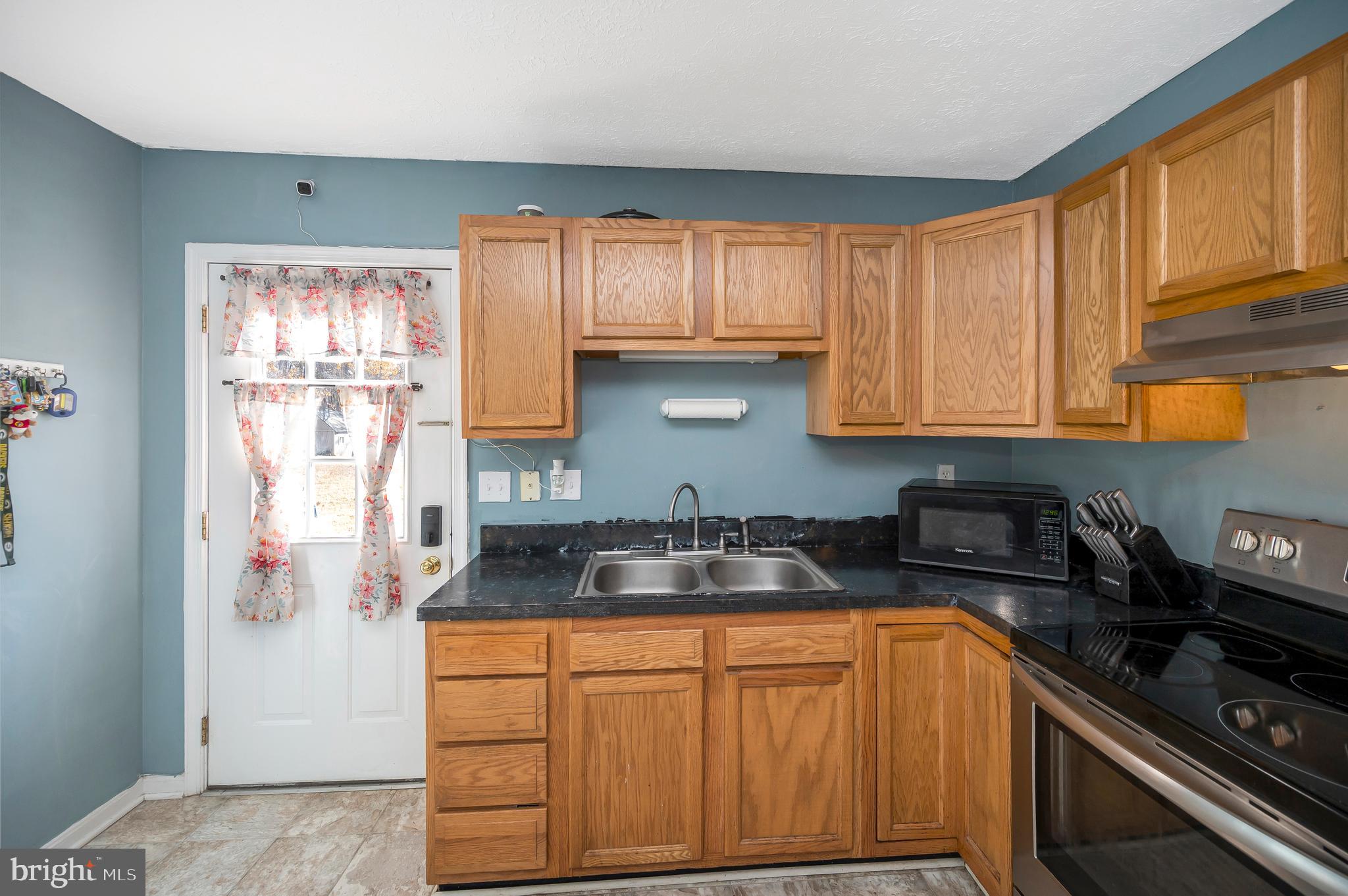 9577 Roys Lane Culpeper, VA 22701 - Photo 12 of 42 a kitchen with stainless steel appliances granite countertop a sink stove and cabinets