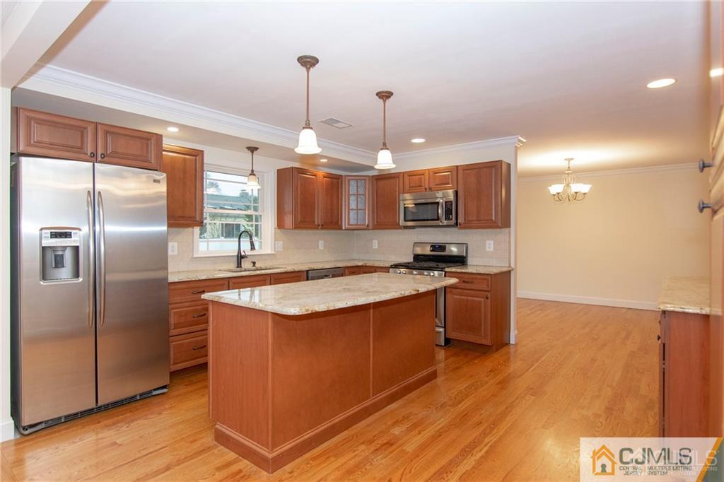 2231 Foster Road Point Pleasant, NJ 08742 - Photo 4 of 25 a kitchen with stainless steel appliances granite countertop a refrigerator a sink dishwasher a stove and a wooden floor