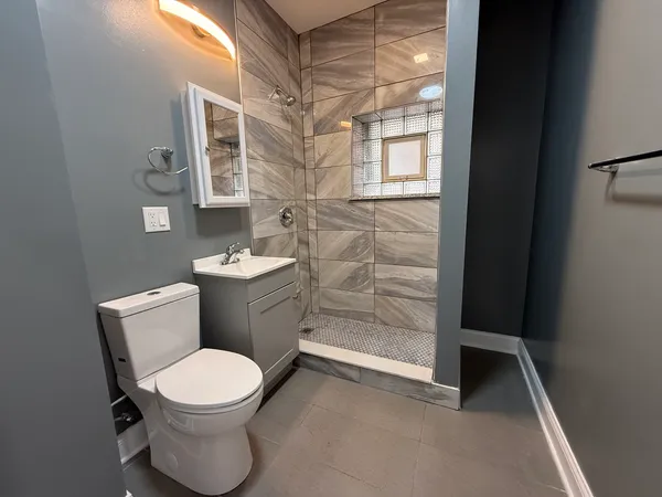 a bathroom with a toilet a sink and shower