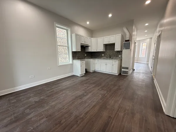 a view of kitchen with stainless steel appliances refrigerator stove microwave and cabinets