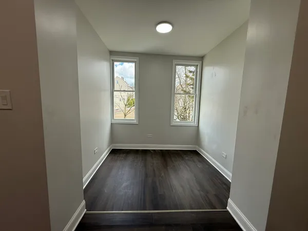 an entryway view with wooden floor and windows