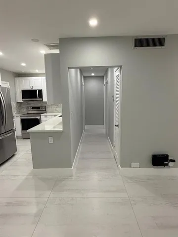 a kitchen with stainless steel appliances a refrigerator and a stove top oven