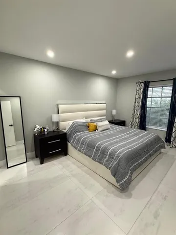 a bedroom with a bed and a large mirror