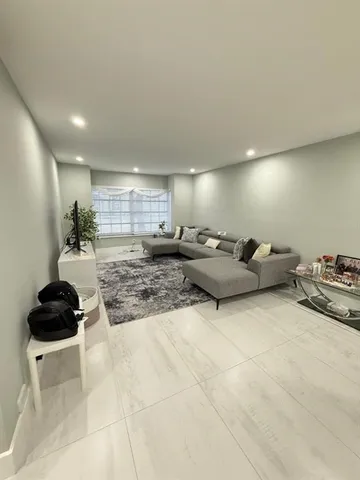 a living room with furniture and a air conditioner vent